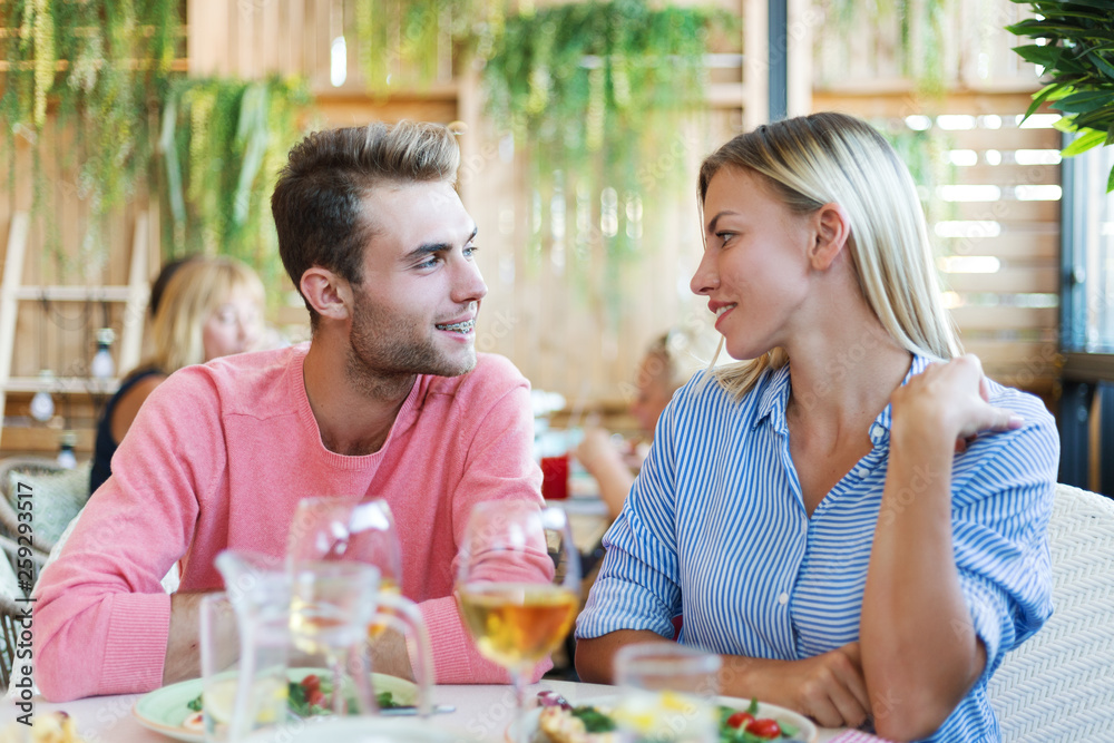 Beautiful young couple looking at each other with affection while having dinner in restaurant Beautiful young couple looking at each other with affection while having dinner in restaurant