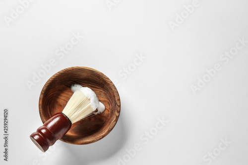 Bowl and shaving brush on white background