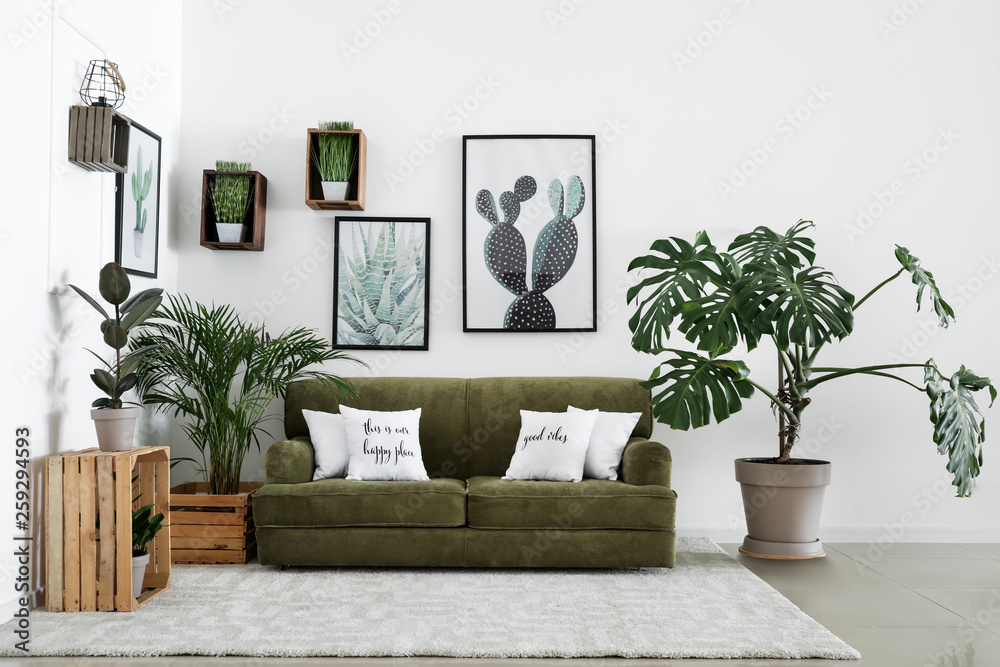 Interior of modern room with comfortable sofa and houseplants - obrazy, fototapety, plakaty 