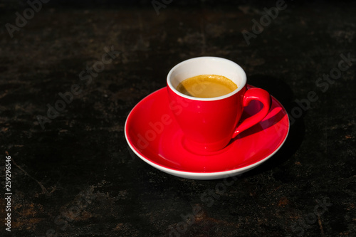 Espresso in roter Tasse auf schwarzem Tisch