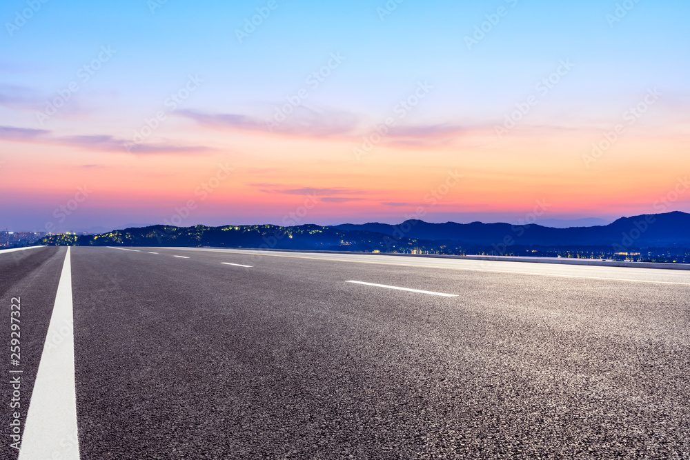 Fototapeta premium Asphalt road and beautiful mountain nature landscape at sunset