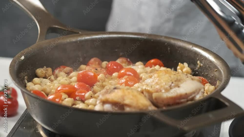 Cooking chicken pieces in roasted vegetables on hot iron pan by chef hands. Food concept video footage for recipe. Cooking chicken pieces in roasted vegetables on hot iron pan by chef hands. Food concept video footage for recipe.