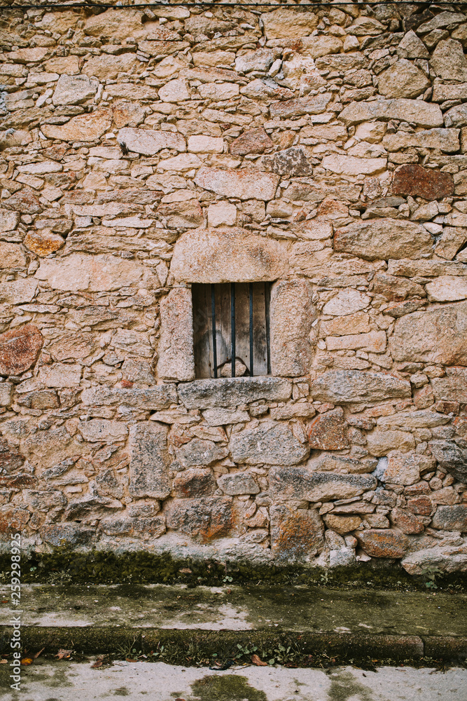 vertical background of a stone wall with small window in the middle