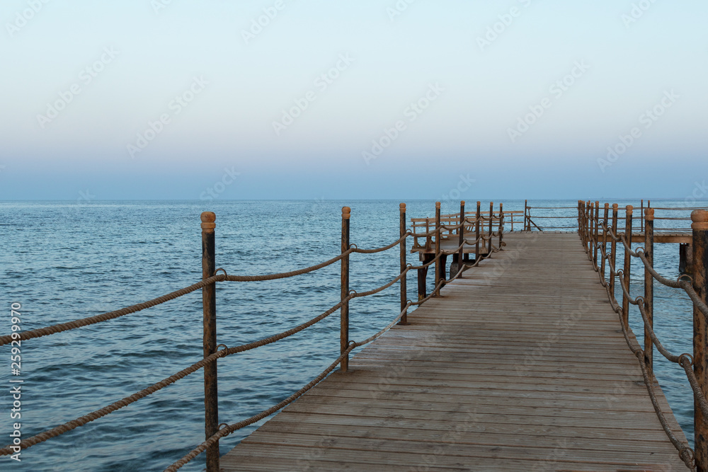 deserted long  old wooden pier at sunset time