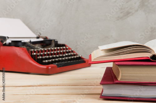 vintage typewriter and books on the table with blank paper on wooden desk