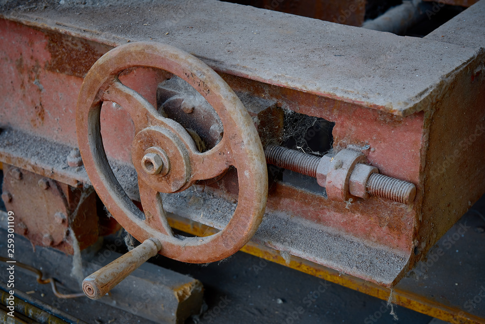 turn the wheel. old rusty detail of a shipping mechanism in an abandoned factory
