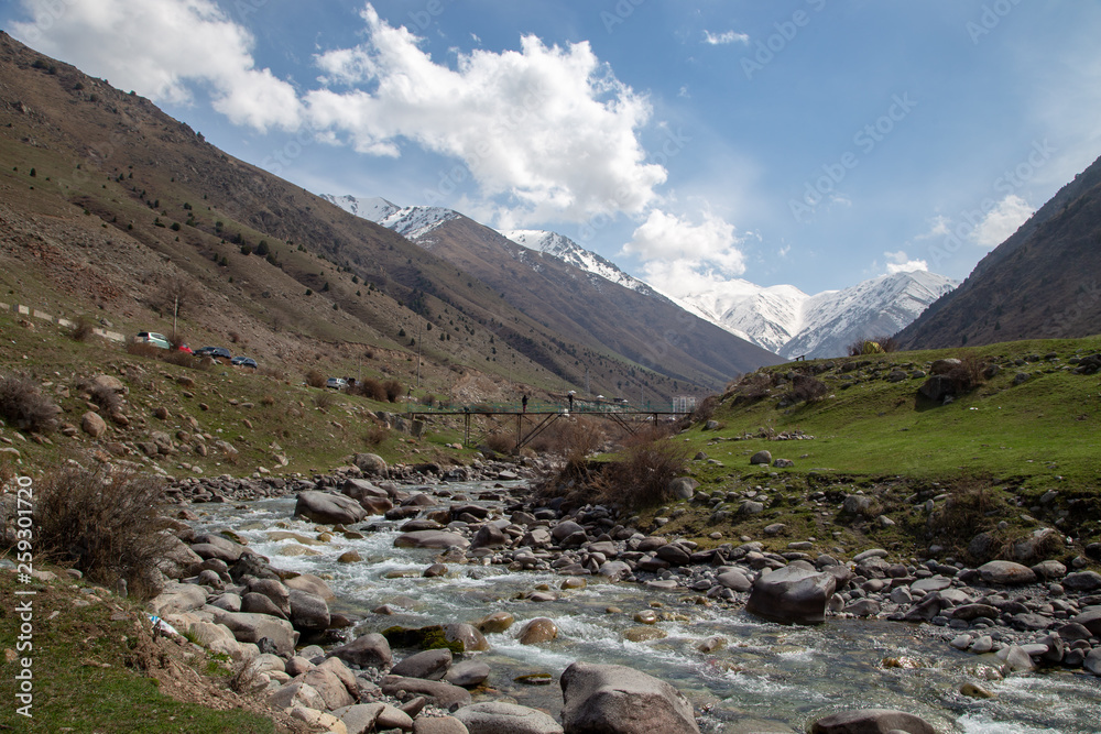 Mountain spring landscape. Mountain river, blue sky. Day after town in the mountains. Spring mood. Green grass. Mountain spring landscape. Mountain river, blue sky. Day after town in the mountains. Spring mood. Green grass.