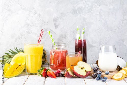 Selection of colourful smoothies in glasses with ingredients