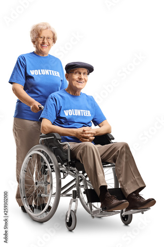 Senior volunteer woman with a senior volunteer man in a wheelchair posing