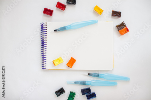 Bright stationery for drawing: paper, watercolor paints, brushes with a reservoir