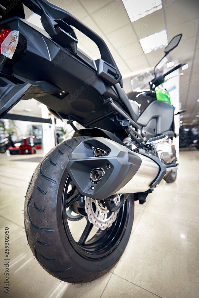 View of the back of a motorcycle with an emphasis on the chain. View of the back of a motorcycle with an emphasis on the chain.