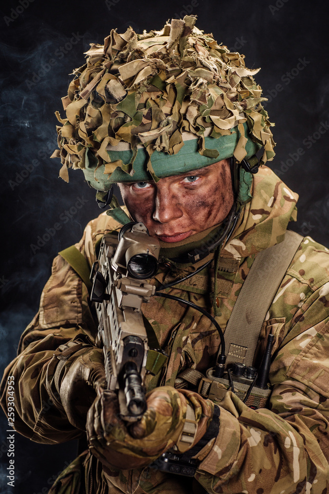 British special forces soldier with weapon take part in military maneuver. war, army, technology and people concept. British special forces soldier with weapon take part in military maneuver. war, army, technology and people concept.