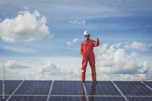 engineers repairing solar panel at generating power of solar power plant ; technician in industry uniform on level of job description at industrial