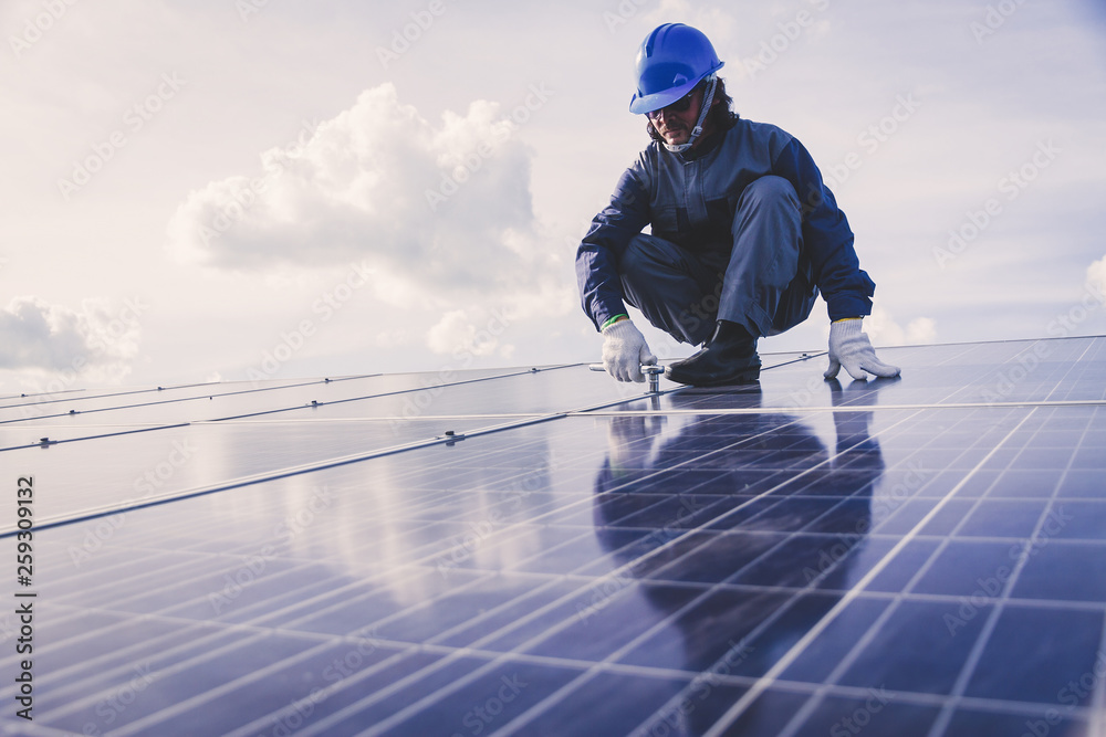 engineers repairing solar panel at generating power of solar power plant ; technician in industry uniform on level of job description at industrial engineers repairing solar panel at generating power of solar power plant ; technician in industry uniform on level of job description at industrial