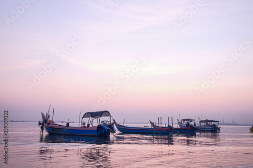 Sunrise at a bay of water and fishing port, the calm sea in low tide, a tranquil scene in morning mood