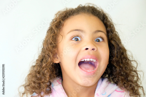 Cute girl daughter curly hair mixed race surprised face