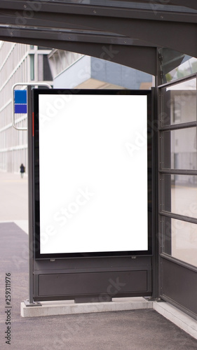 Blank white mock up of vertical light box in a bus stop.Mock up of a billboard. Poster on street at sunny day.