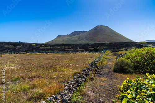 Spain, Lanzarote, Magic monte corona volcano behind lava terraces for winegrowing