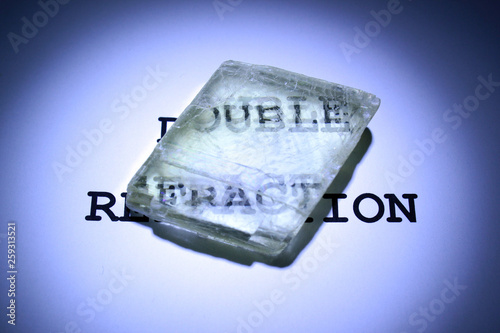 Double refraction of text in iceland spar crystal. Calcite specimen with optical birefringence. photo