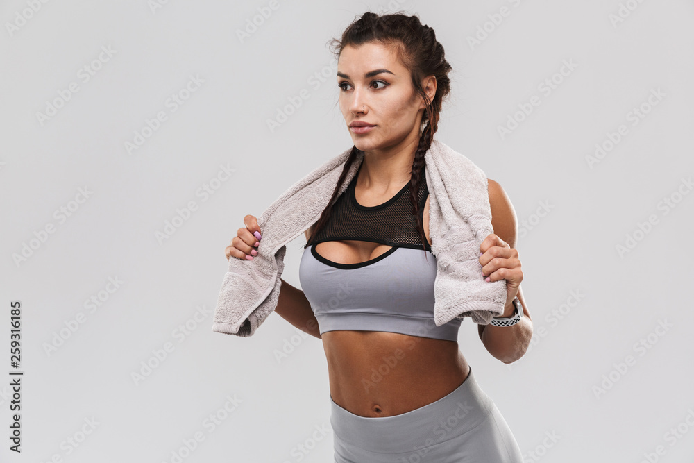 Beautiful young amazing strong sports fitness woman posing isolated over white wall background holding towel. Beautiful young amazing strong sports fitness woman posing isolated over white wall background holding towel.