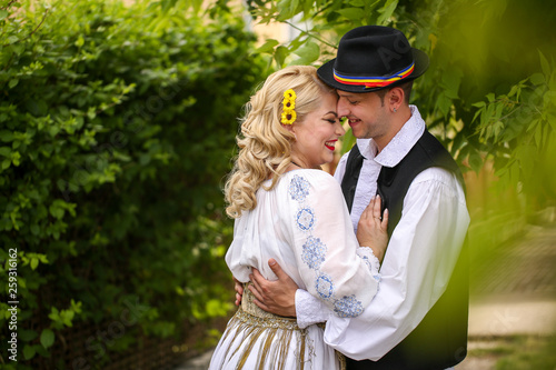 Beautiful couple posing outdoor in traditional clothes