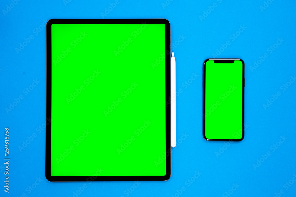 new tablet on a Blue background with and pen, and green screen new tablet on a Blue background with and pen, and green screen