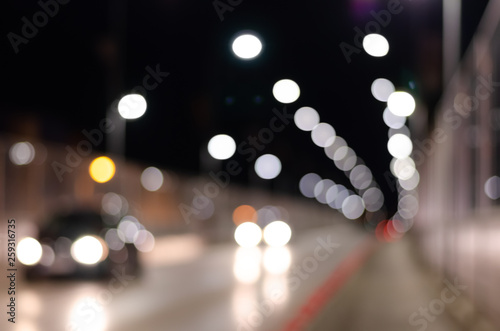 Out of focus   background of city road with multicolored  brightly glowing street lights and moving cars. © SnowMan