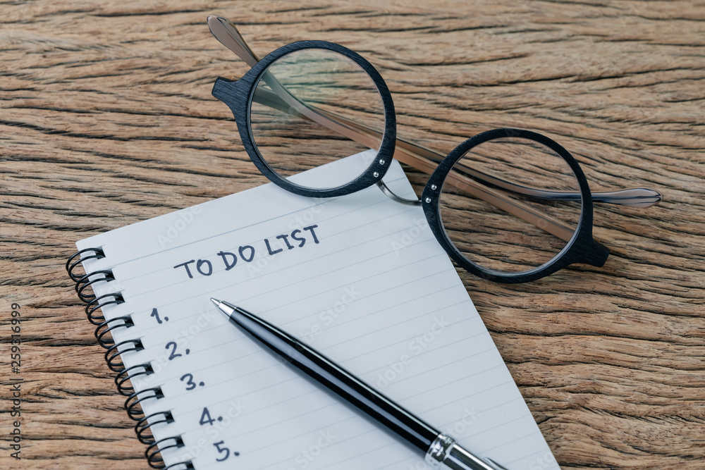Fototapeta premium To do list, checklist of things or tasks to complete for life habit, business project plan concept, black pen on notepad with headline To do list and list of numbers with eyeglasses, wooden table