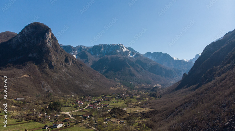 mountaintops with snow in distance and village in valley 