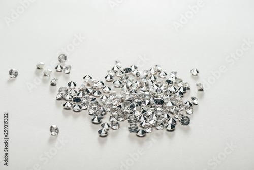transparent pure small diamonds scattered on white background