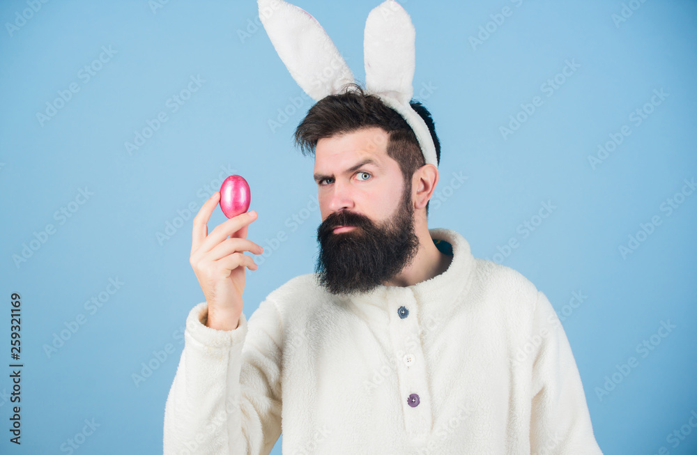 Easter treat. Hipster wearing long rabbit ears with Easter egg. Easter ...