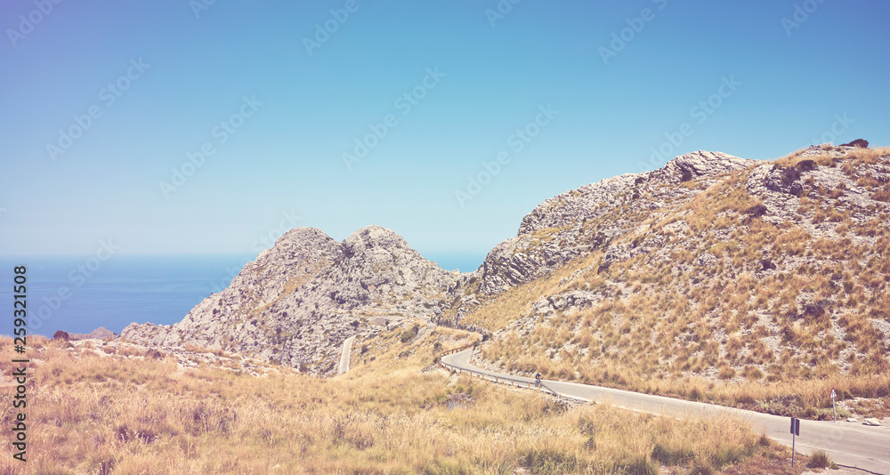 Scenic mountain winding road with sea in distance, color toning applied, Mallorca, Spain.