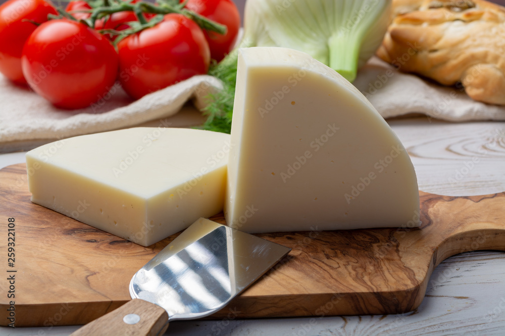 Italian cheese, Provolone dolce cow cheese from Cremona served with olive bread and tomatoes