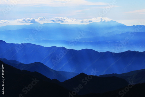南アルプス塩見岳山頂から 光芒に煙る 恵那山 木曽遠景