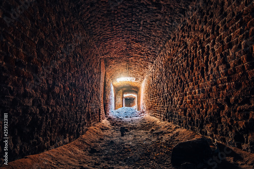 Old underground ruined red brick historical vaulted tunnel