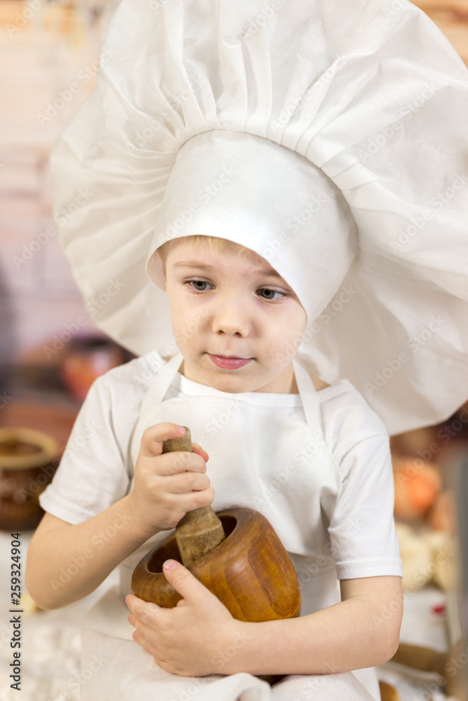 the little boy is preparing cake and pancakes. Dressed like a chef child dough prepares food. the little boy is preparing cake and pancakes. Dressed like a chef child dough prepares food.