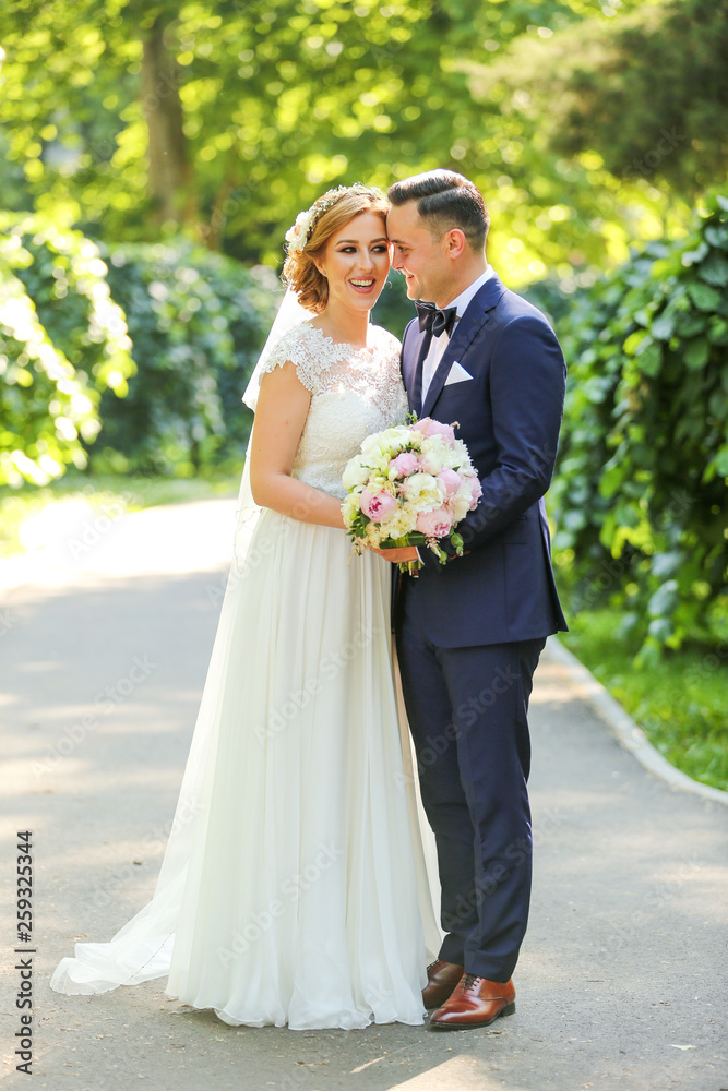 Beautiful wedding couple posing in park Beautiful wedding couple posing in park