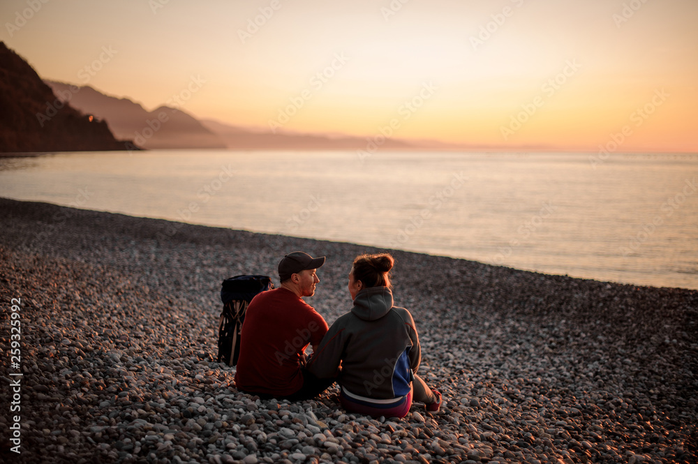 Young romantic couple sitting on the beach