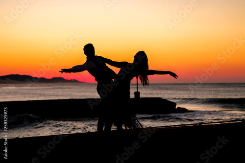 Couple dancing on the pier during sunrise make for awesome silhouettes