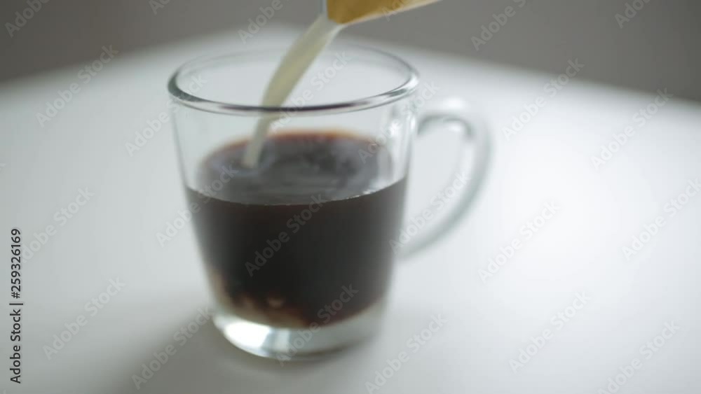 Coffee break and office situation. Pouring coffee and milk into a glass mug. Coffee break and office situation. Pouring coffee and milk into a glass mug.