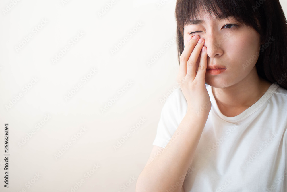 Asian woman suffering from eyes pain and feeling something in her eye. Cause of pain include contact lens problem, conjunctivitis, foreign object, dry eye syndrome or allergy. Copy space. Asian woman suffering from eyes pain and feeling something in her eye. Cause of pain include contact lens problem, conjunctivitis, foreign object, dry eye syndrome or allergy. Copy space.