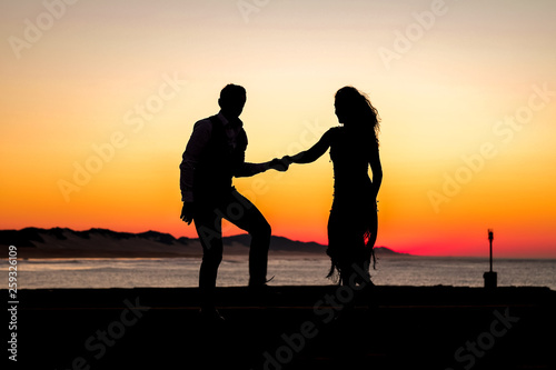 Couple dancing on the pier during sunrise make for awesome silhouettes