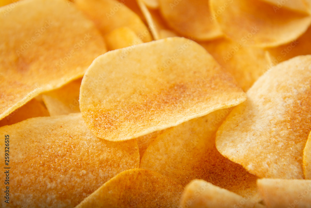 Background golden potato chips texture. Crispy unhealthy snack isolated.
