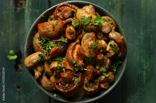 Fotografie Baked mushrooms with balsamic vinegar in a rustic bowl