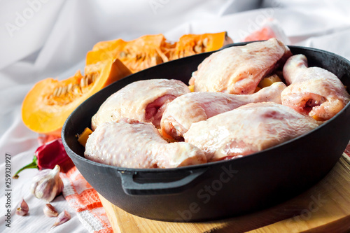 Cooking one-pot meal - chicken thighs and legs with potatoes and pumpkin