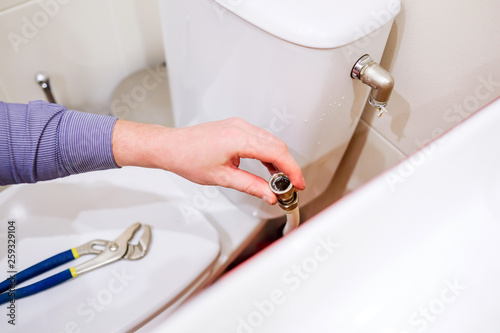 Sanitary worker performs repair of toilet bowl