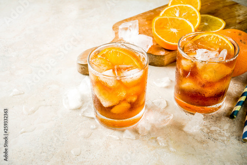 Cold summer cocktail, Iced coffee dink with orange slices, stone table copy space