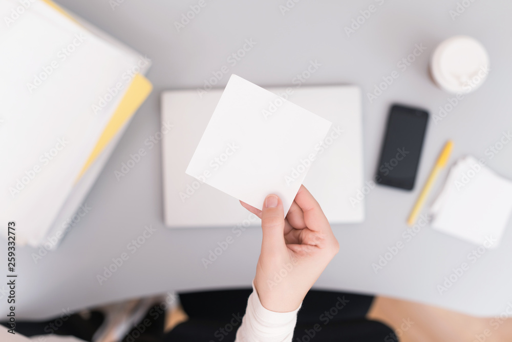 Woman clerk in the office holding empty note sticker for any message. Concept. Space for text Woman clerk in the office holding empty note sticker for any message. Concept. Space for text