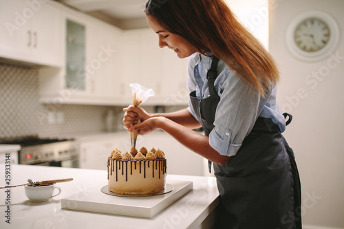 Woman piping decoration on a cake