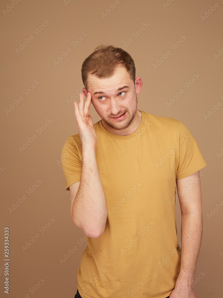 young man in yellow shirt looking upholds on the head young man in yellow shirt looking upholds on the head